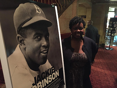 JMS Associate Professor Khadijah Costley White with a poster of the Jackie Robinson documentary. 